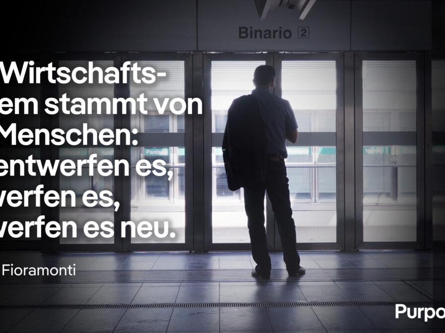 Lorenzo Fioramonti steht in einem gläsernen Bereich vor dem Einstieg in eine U-Bahn, darauf sein Zitat: 'Das Wirtschaftssystem stammt von uns Menschen: Wir entwerfen es, verwerfen es, entwerfen es neu.'
