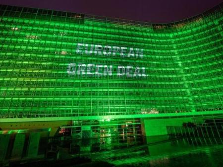 Das Berlaymont-Gebäude, Sitz der Europäischen Kommission, Nachtaufnahme, grün illuminiert mit dem Schriftzug 'European Green Deal'