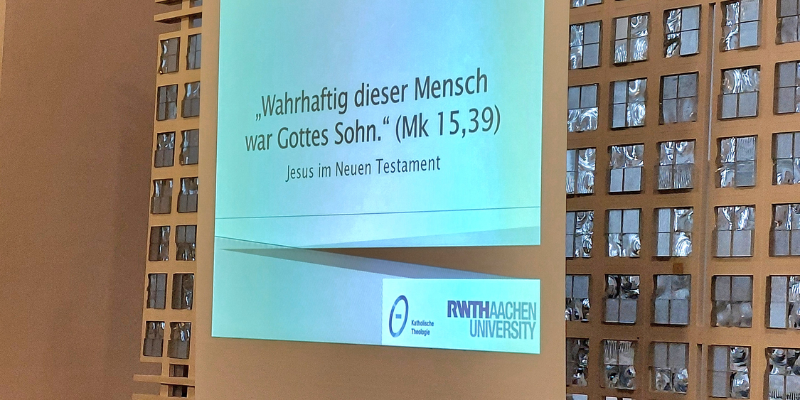 Leinwand mit Folienpräsentation, hier das Zitat: 'Wahrhaftig, dieser Mensch war Gottes Sohn' (Mk 15,39).