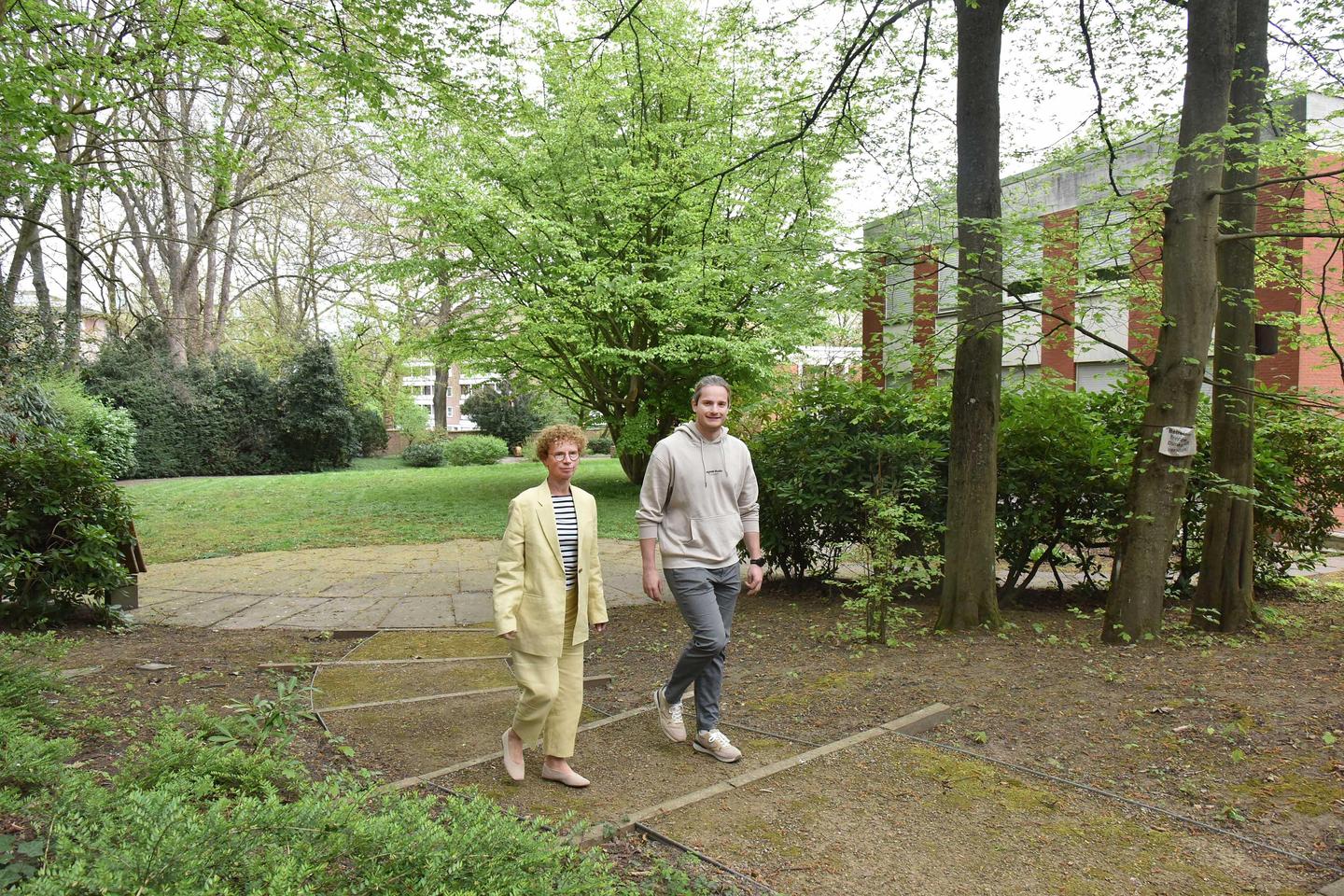 Ein Mann und eine Frau gehen über einen Weg im Akademiegarten.