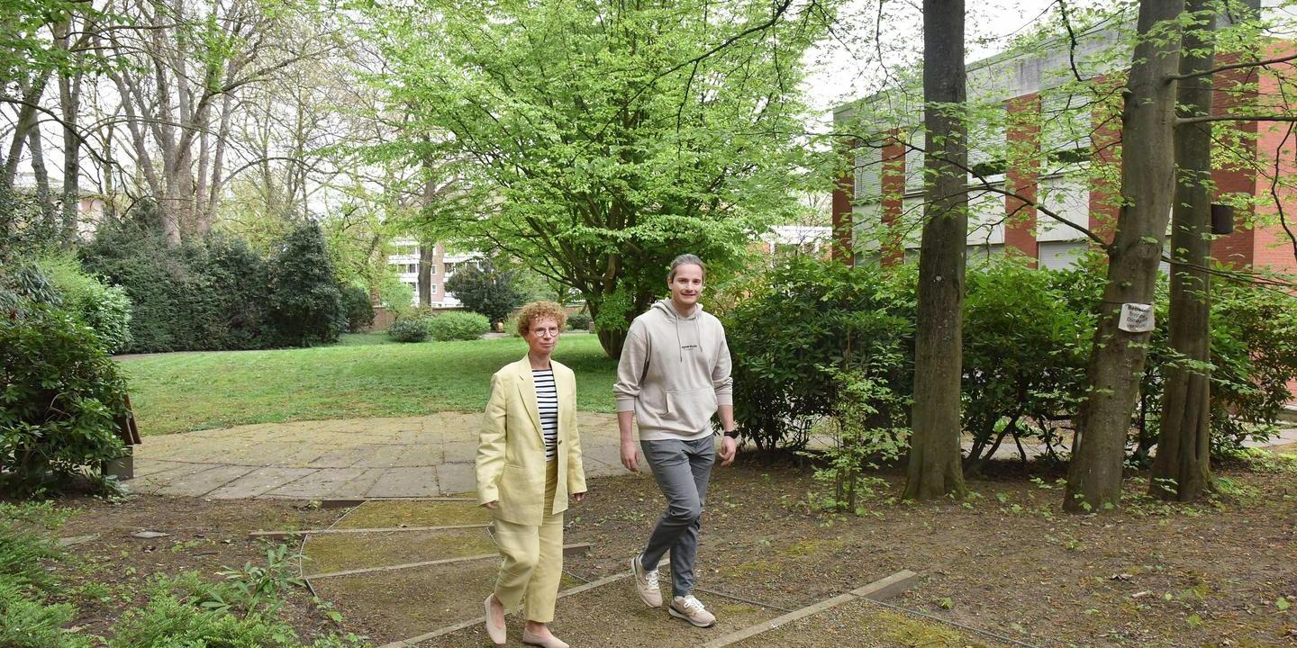Ein Mann und eine Frau gehen über einen Weg im Akademiegarten.