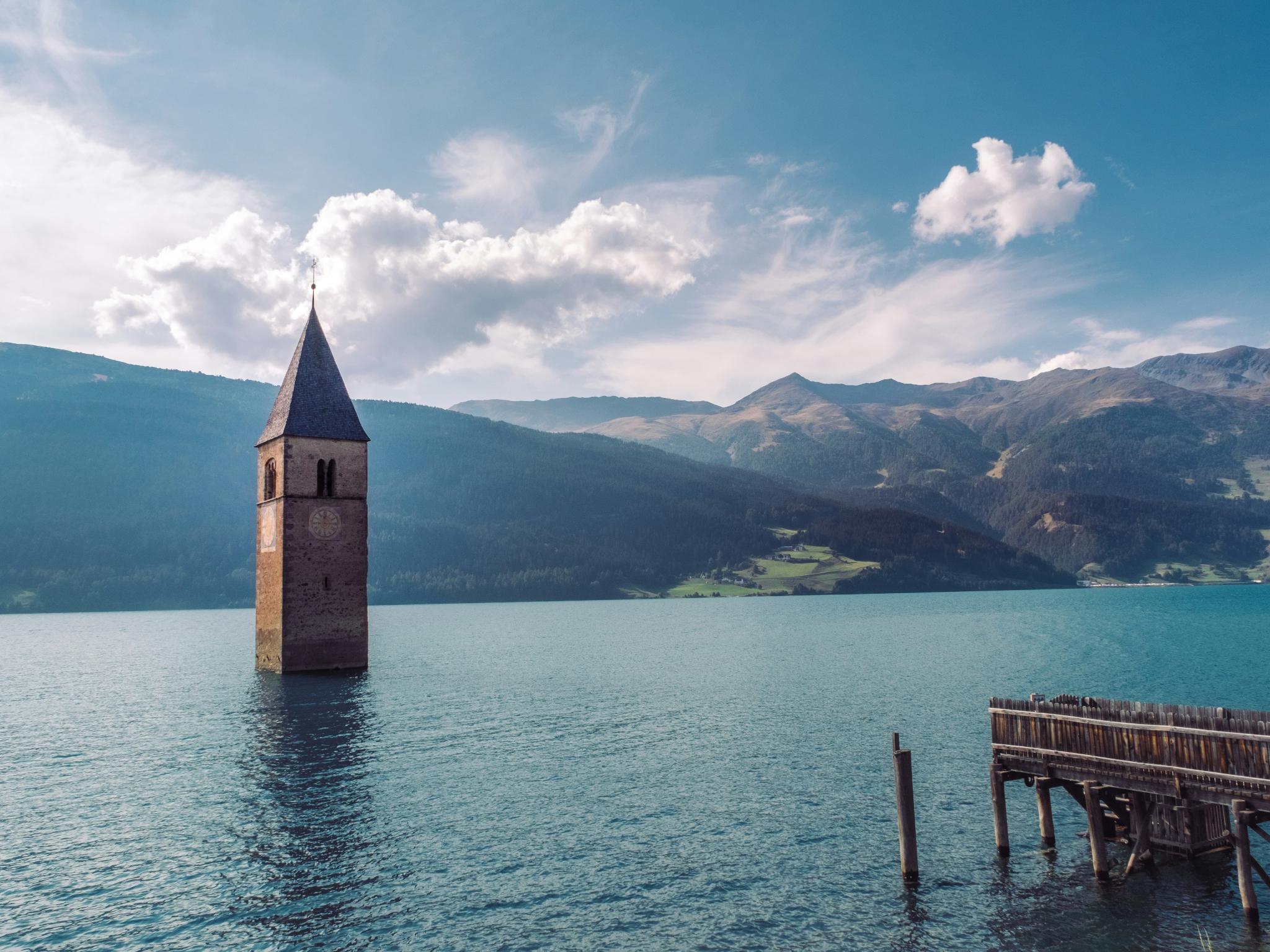 Kirchturm ragt aus der Wasseroberfläche, das Gebäude scheint darunter zu liegen